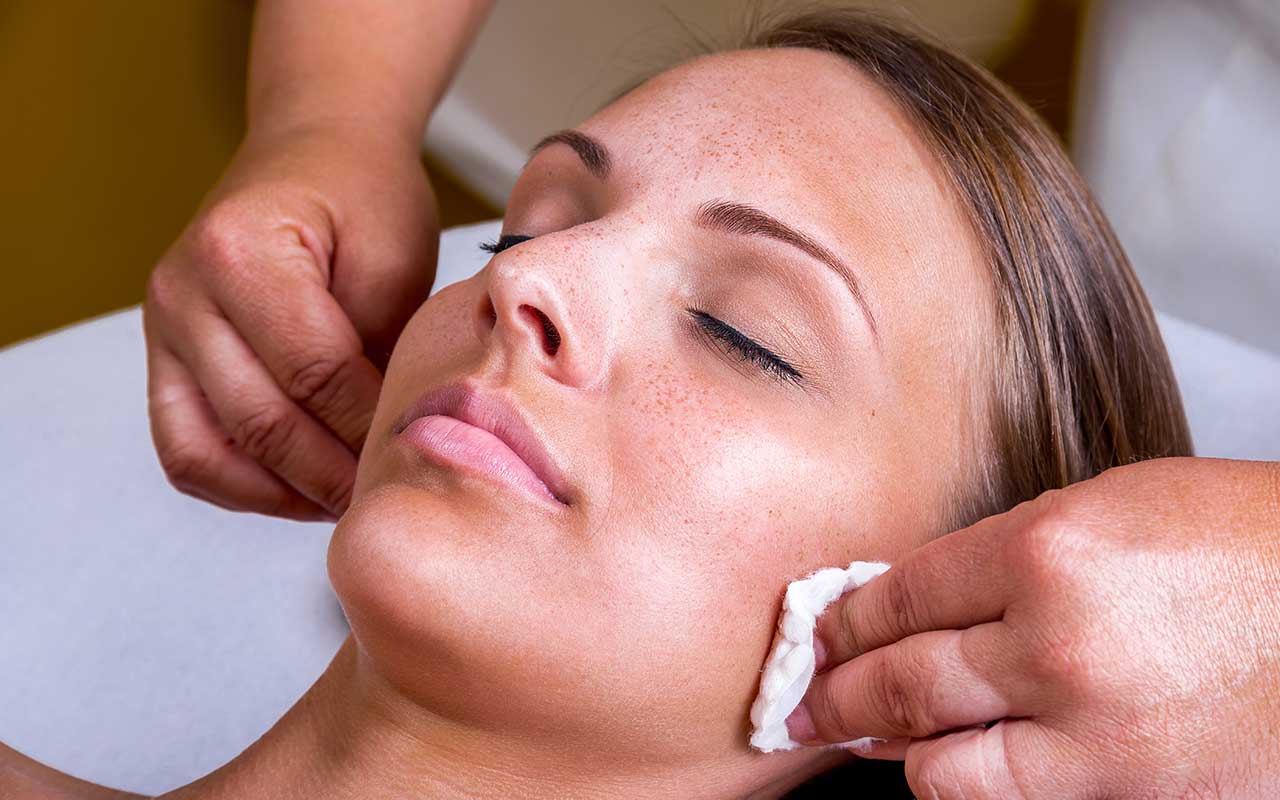 lady with eyes closed having a facial peel